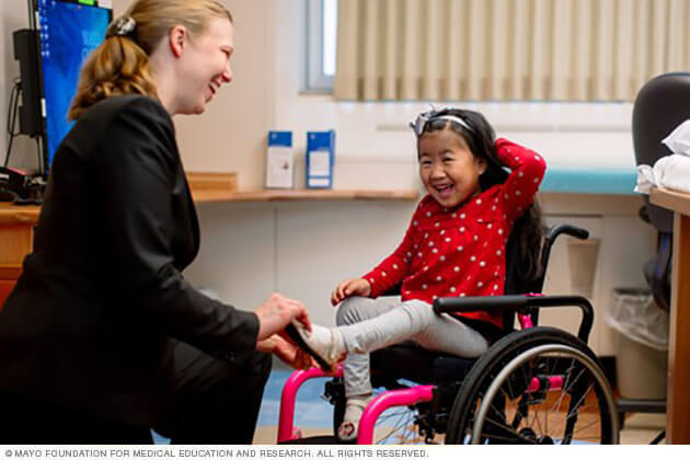 A child giggles as her Mayo doctor wiggles her toes during a CPSB Clinic visit.